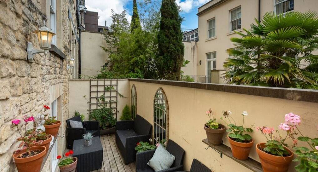 The private walled patio terrace with wicker seating at Sundeck Bath, a central Bath hen party cottage.